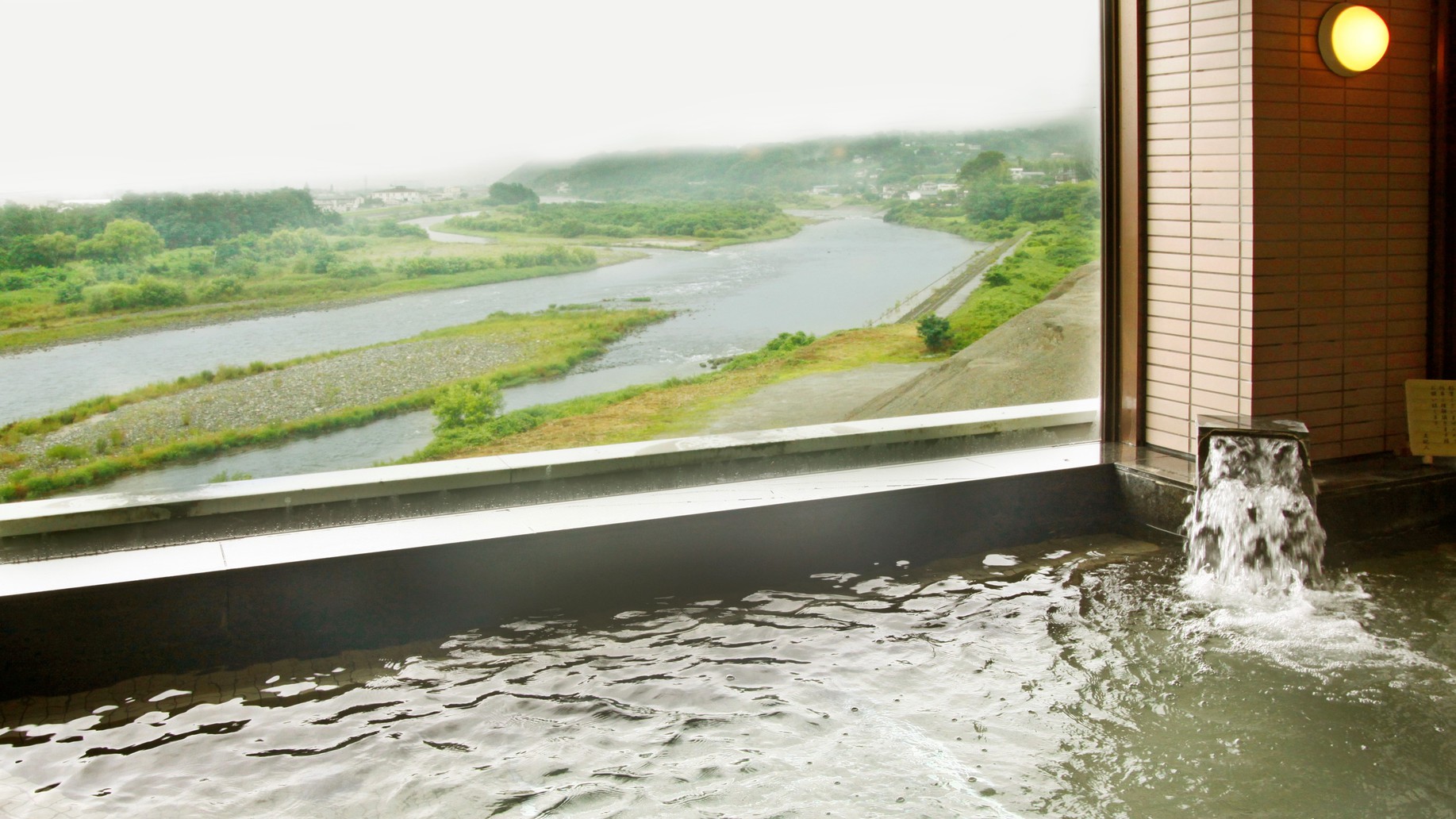 【男性大浴場】大きなガラス窓から、昼は天竜川の悠々たる流れ、夜は飯田市街地の夜景を一望できます