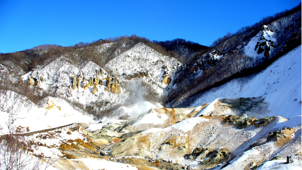 【冬の地獄谷】雪に覆われた地獄谷とその合間から立ち上る源泉の湯気。