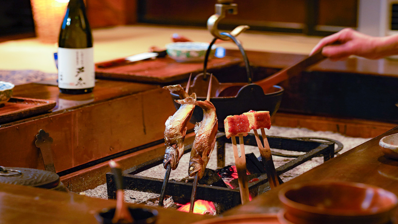 夕食風景一例。盃を交わし、いろり炭火を交えながら芦名の料理をお楽しみください。