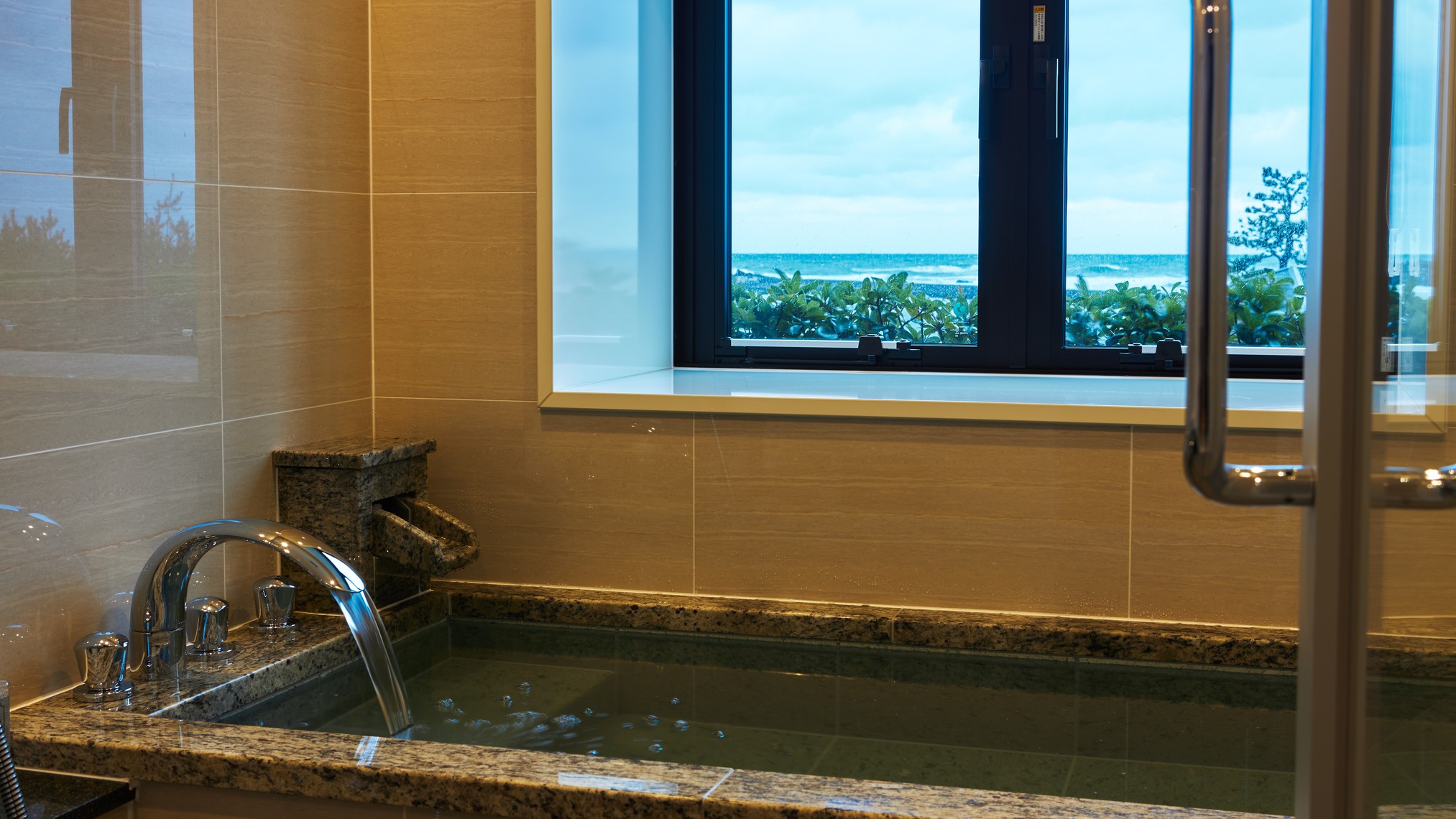 【温泉付客室「花の波」】客室の天然石の温泉風呂からも日本海を一望できます。