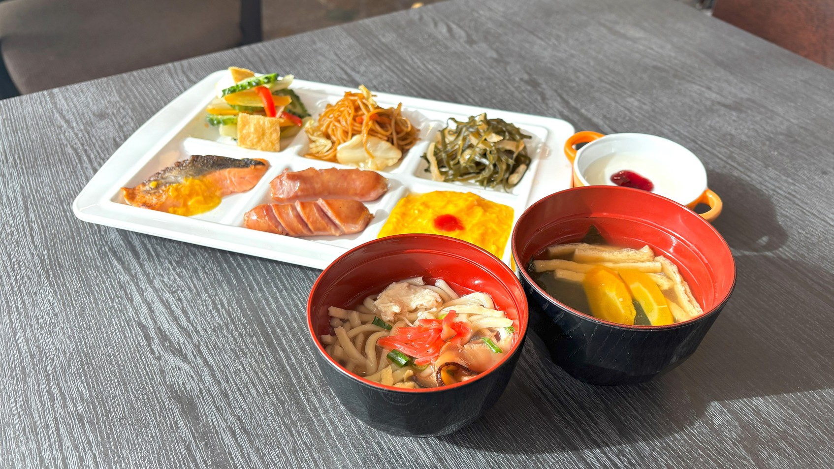 窓の外に広がるモノレールビューと共に、沖縄の伝統的な味わいを楽しむ朝食バイキング。