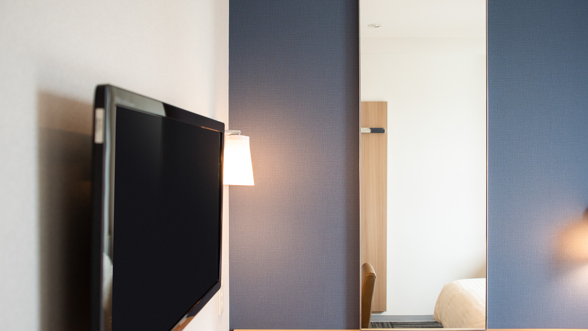 ベッドから見やすい位置にある壁掛けテレビ