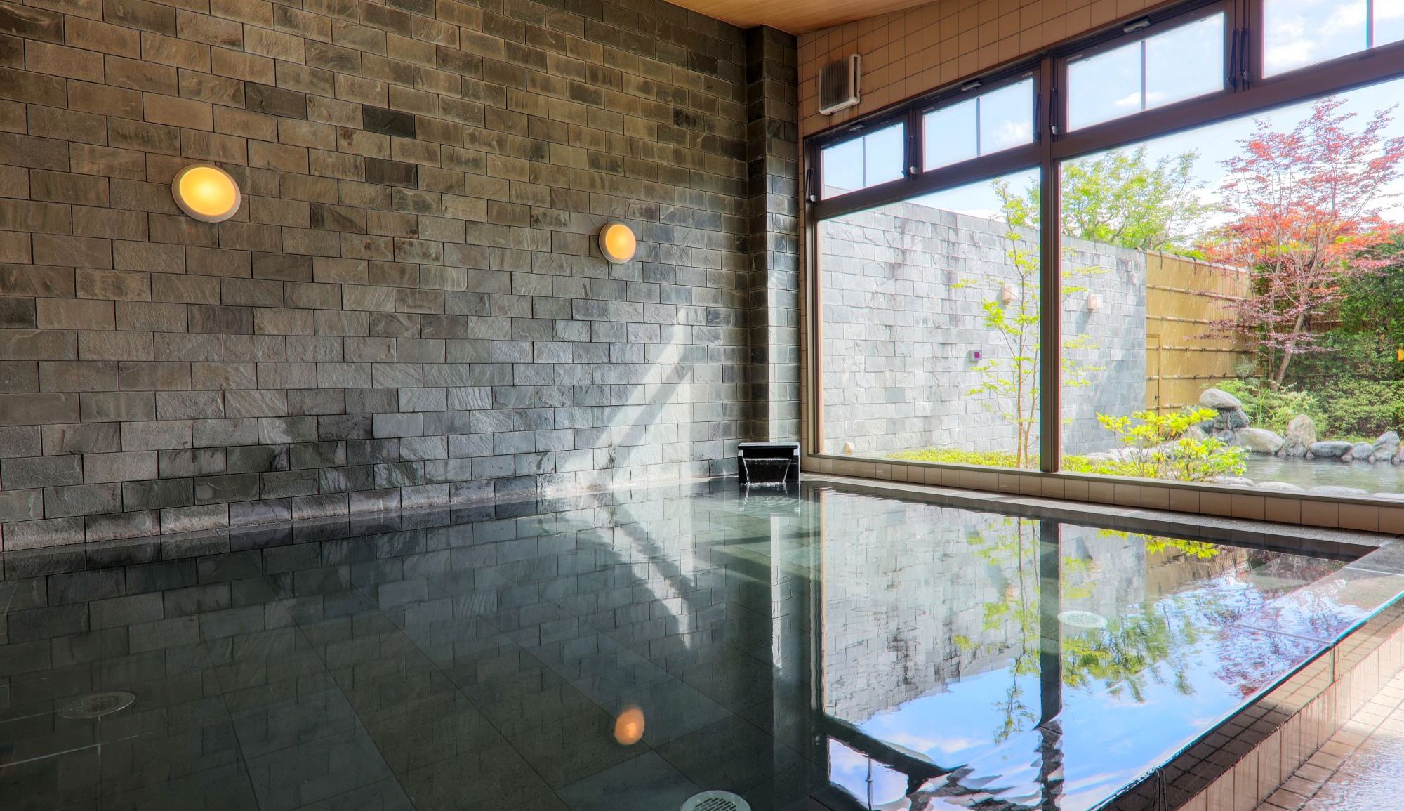 【内風呂】ひばの木の浴槽内に富士熔岩石を一面に敷きつめ、温泉成分と溶岩石の成分の両方が楽しめます