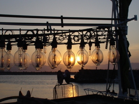 イカ釣り船のライトが夕日に染まる