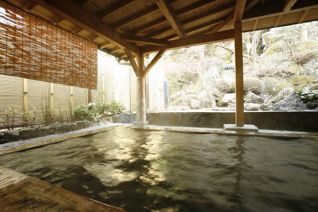 【露天風呂（女湯）】大浴場に併設された露天風呂では庭園と滝を眺めることができます。