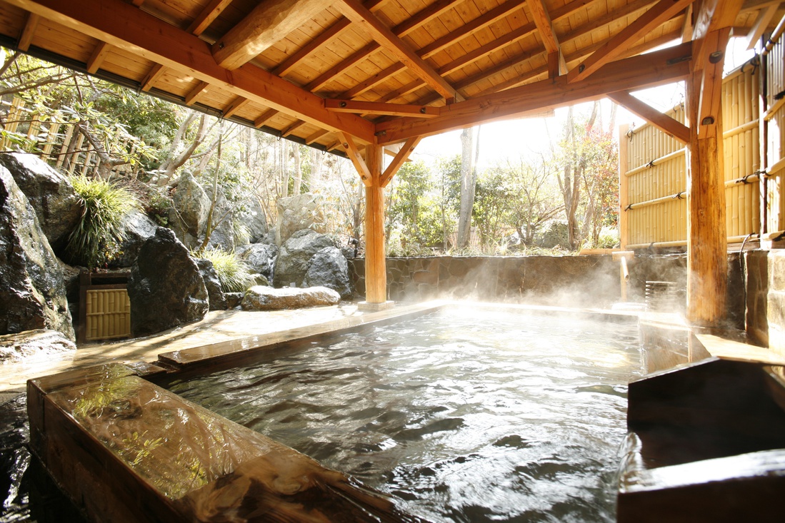 【露天風呂（男湯）】大浴場に併設された露天風呂では庭園と滝を眺めることができます