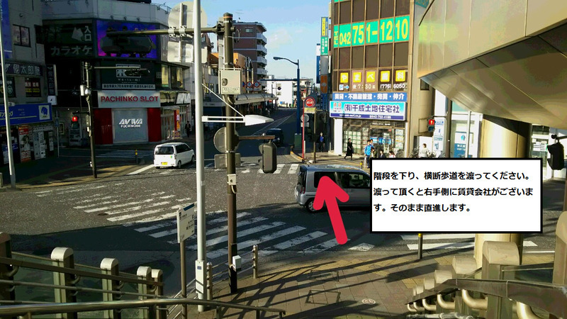 階段を下り、横断歩道を渡ってください。右側に賃貸会社が御座います。そのまま直進します