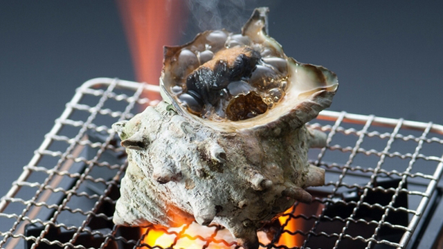 一品料理『サザエのつぼ焼き』。香ばしい磯の風味をお楽しみください。